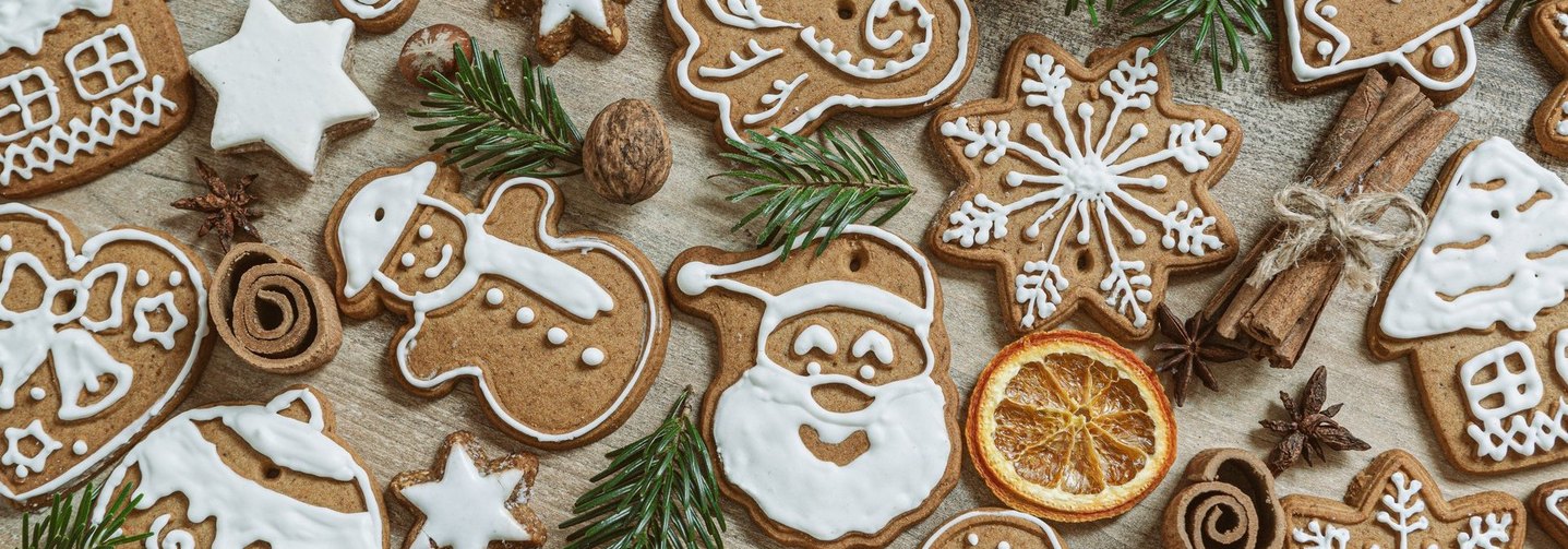 Weihnachtsbäckerei: Verschiedene braune Lebkuchen mit Zuckerguss auf einer Holzfläche.