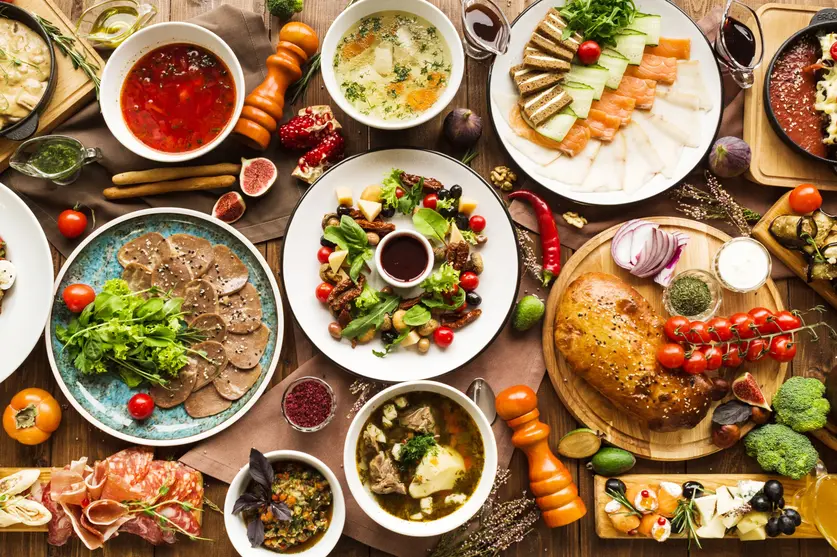 Die österreichische Bevölkerung kann aus einer großen Vielfalt an Lebensmitteln – hier verschiedene Gerichte auf Tellern auf einem Tisch – wählen.